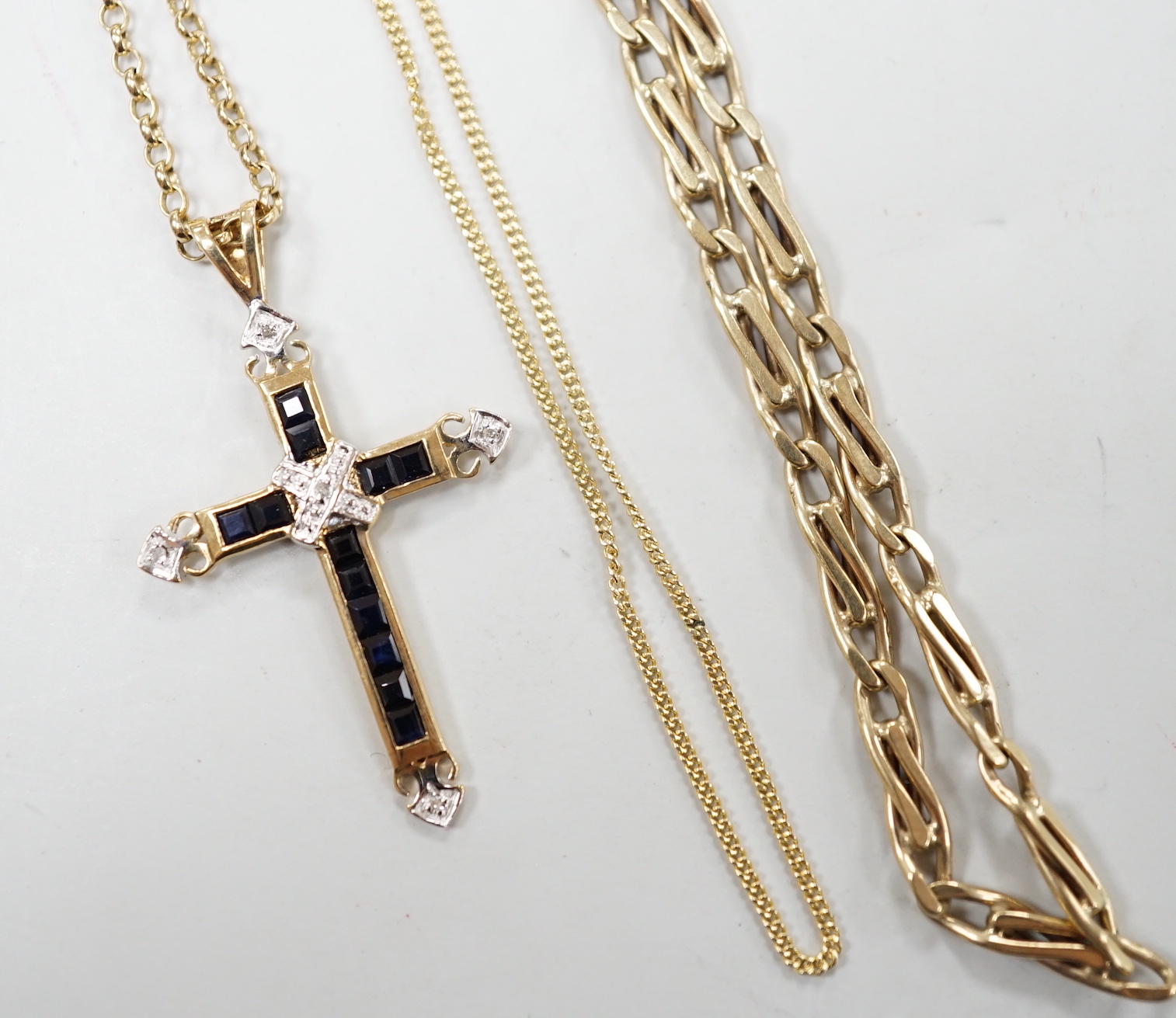 A modern 9ct gold, sapphire and diamond cluster set cross pendant, 33mm, on a 9ct gold chain and two other 9ct gold chains, gross weight 17.5 grams.